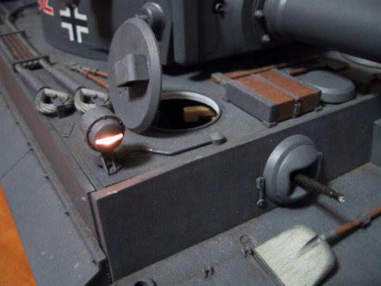 Ich habe eine Glühbirne im Bosch-Scheinwerfer Gehäuse eingebaut. Die innere Fläche vom Gehäuse wurde mit Alu-Folie bedeckt, damit das Licht nicht durchscheint. Die Stromversorgung sind zwei AAA Batterien und der Schalter ist unter der Luke (Nr.50).